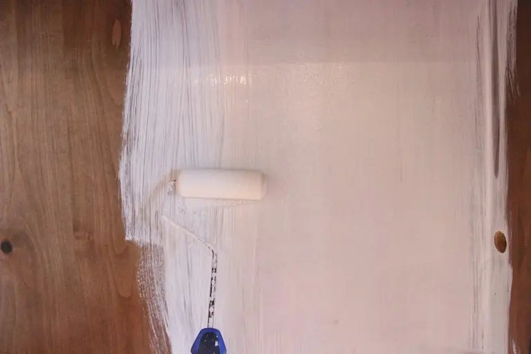 white paint rolled onto cabinet