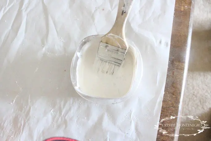 Paint brush in white paint on white paper