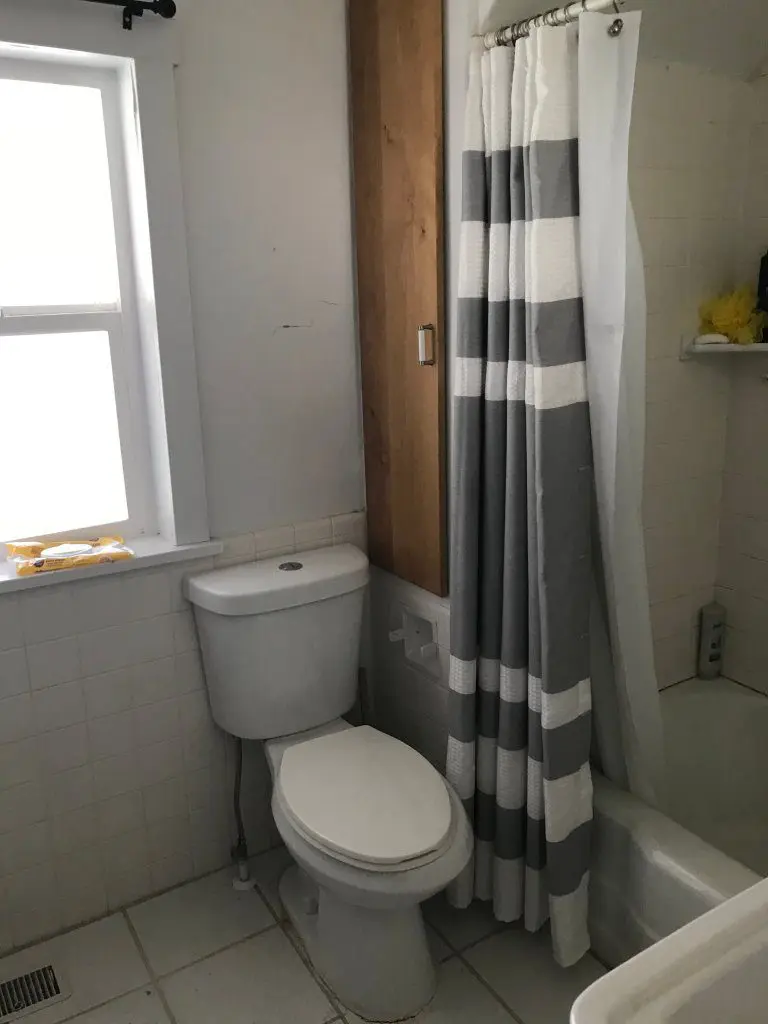 Bathroom shower and toilet with grey and white shoer curta