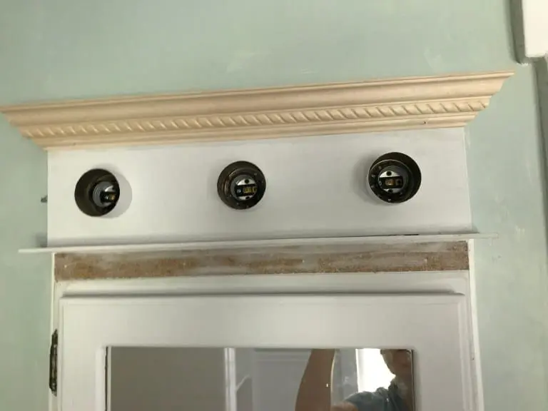 White medicine cabinet with crown molding and green walls