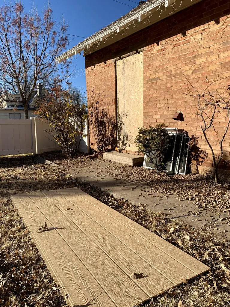 Side of the house with plywood for a door