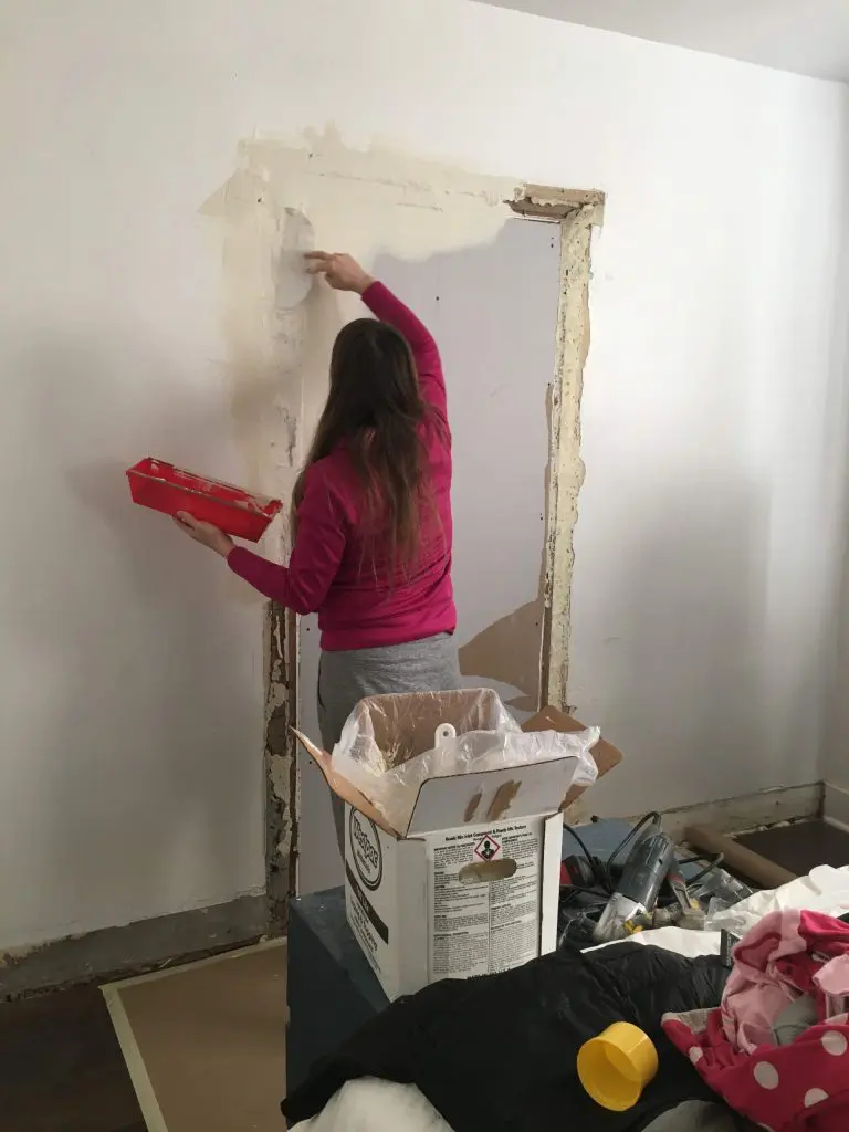 Woman putting joint compound on the wall