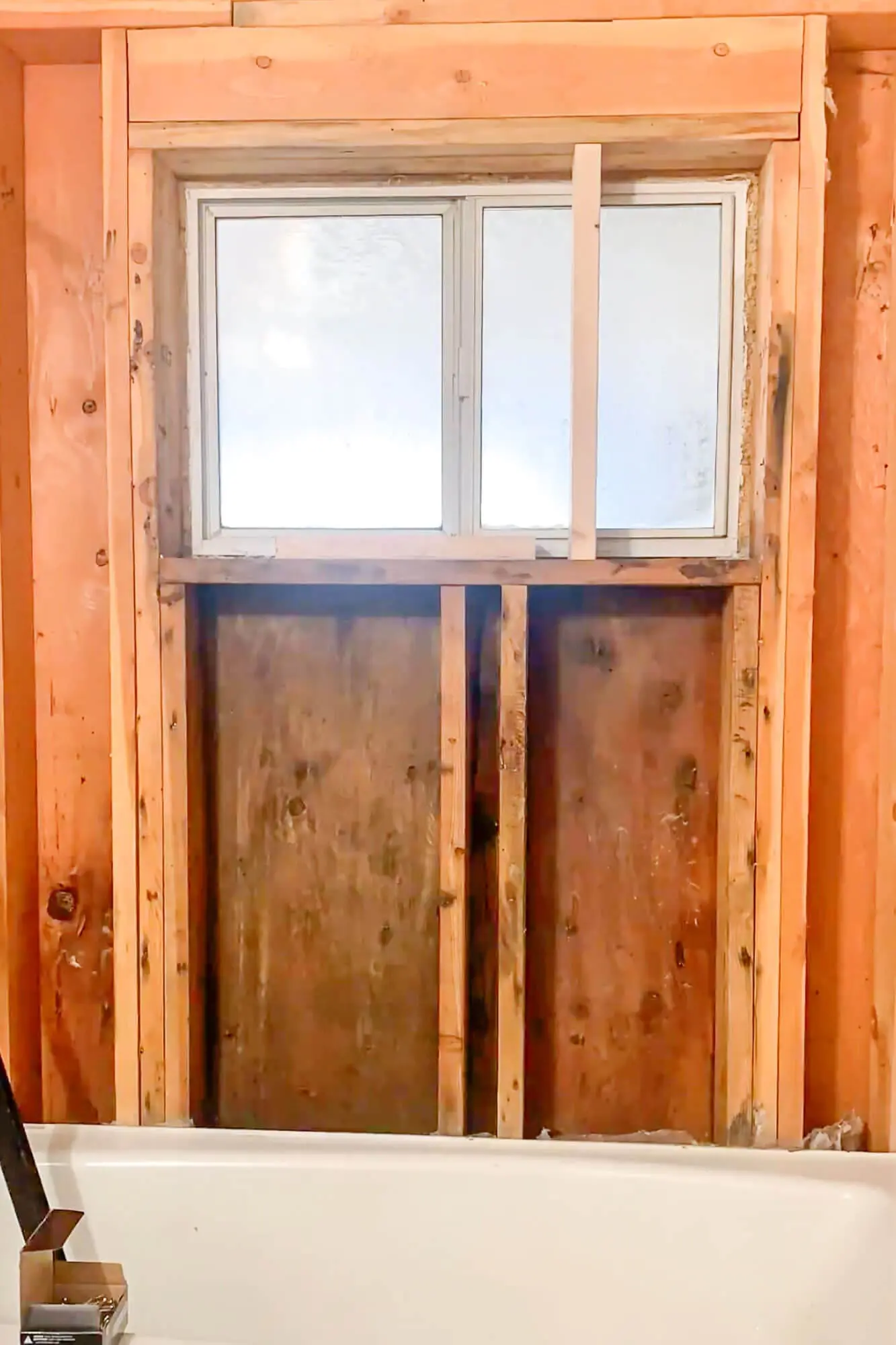 Studs exposed around interior window during shower mold cleanup.