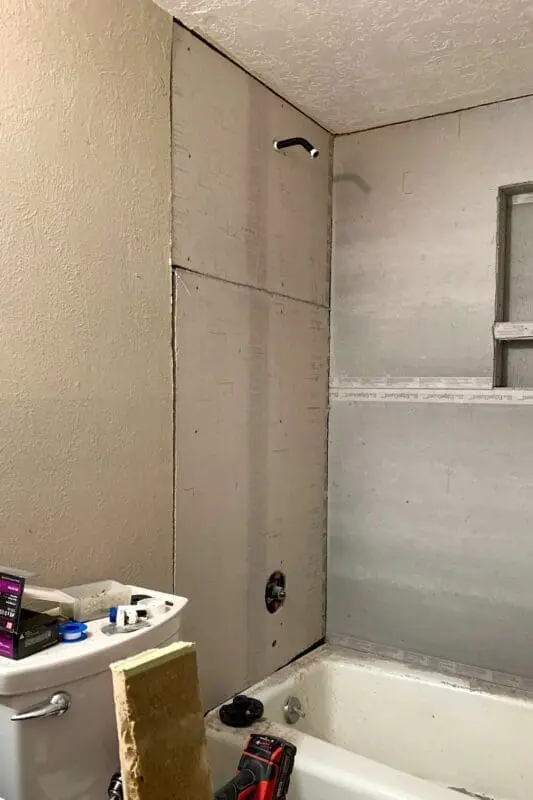 Cement board installed around shower niche and plumbing.