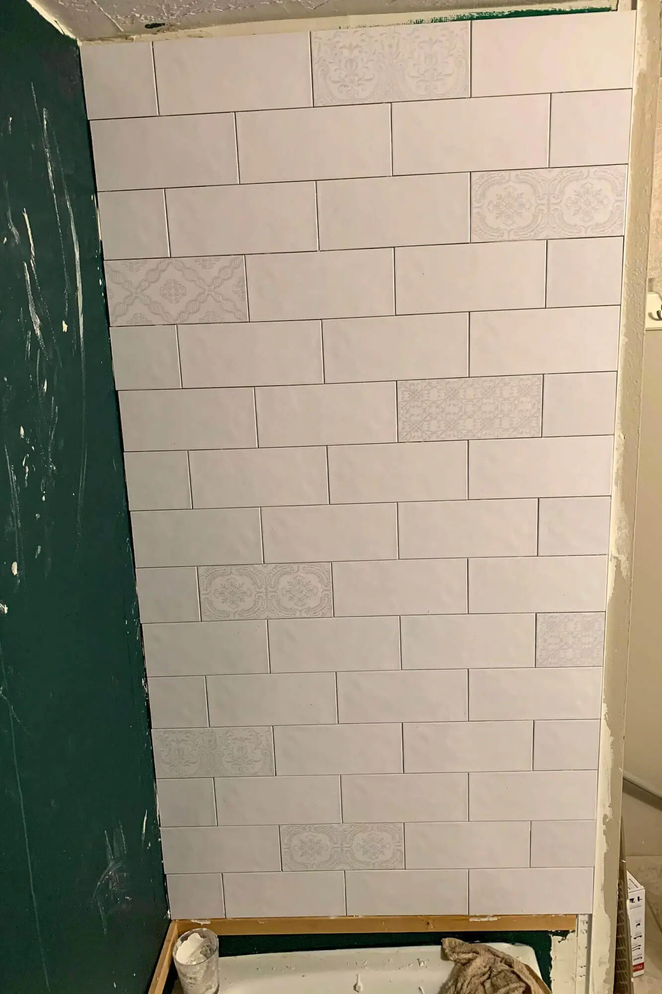 Close-up of even subway tile pattern on shower wall.