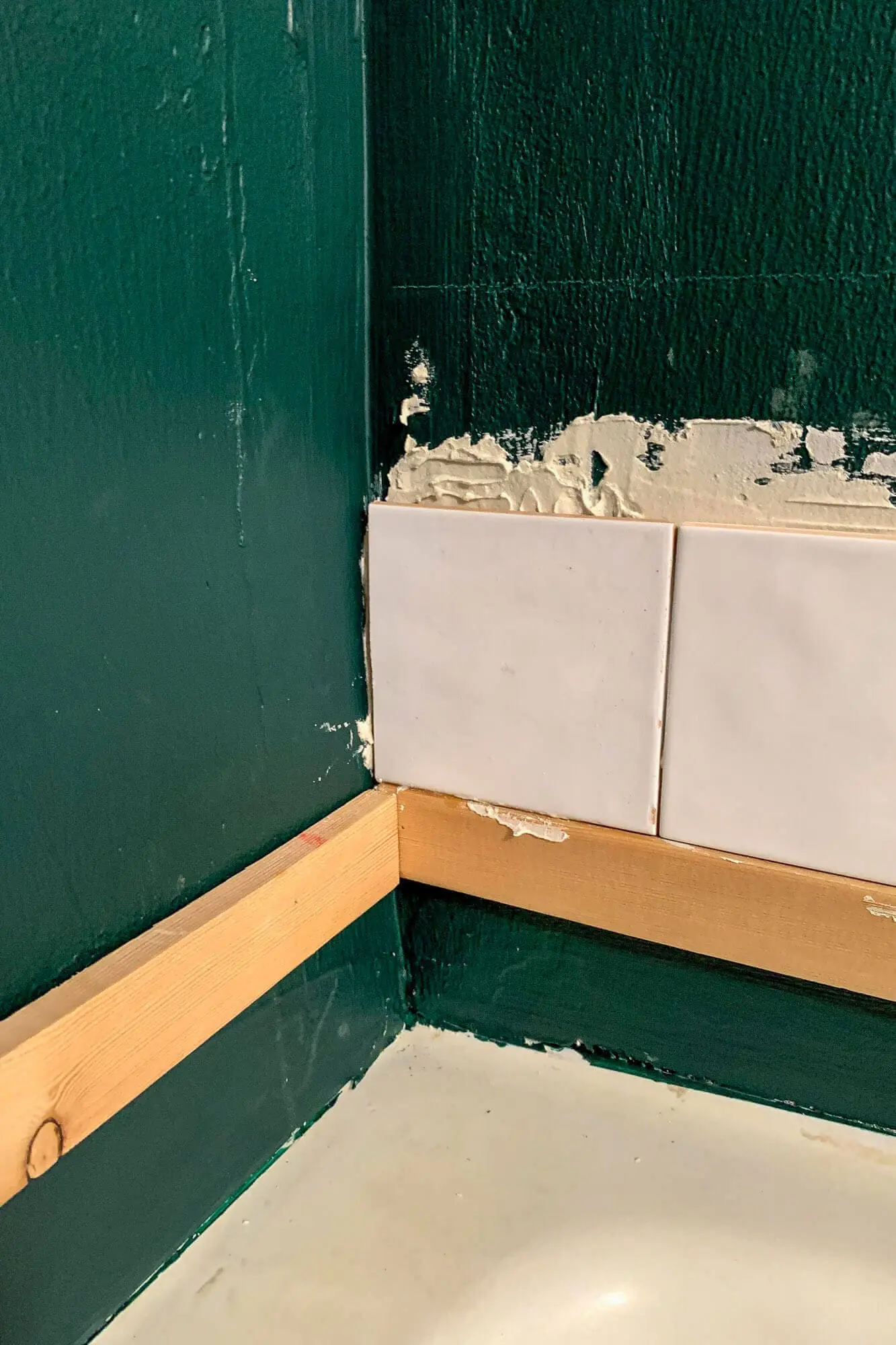 Close-up of even subway tile pattern on shower wall.