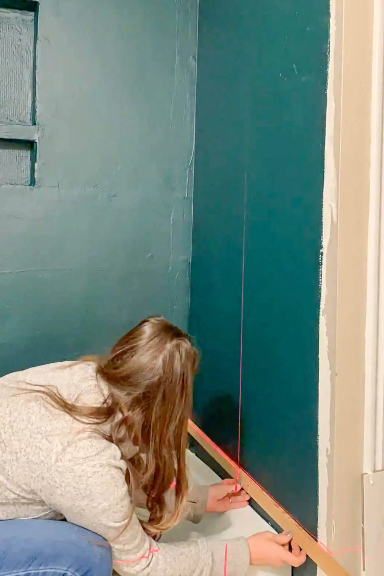 Installing wood ledger board along level line on shower wall.