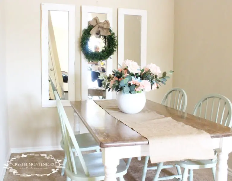 Mirrors and a kitchen table with flowers on top