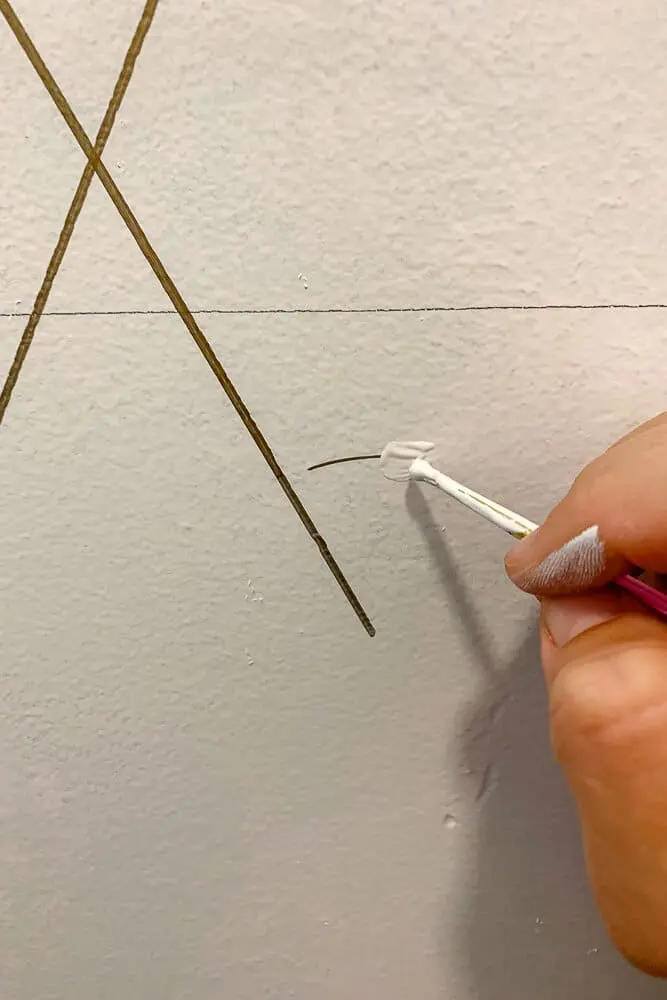 Woman painting bathroom wall white
