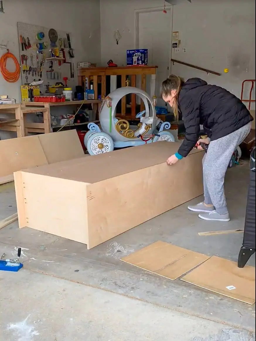 DIY office cabinets being painted with a smooth white finish, transforming unfinished built-ins into a polished home office storage solution.