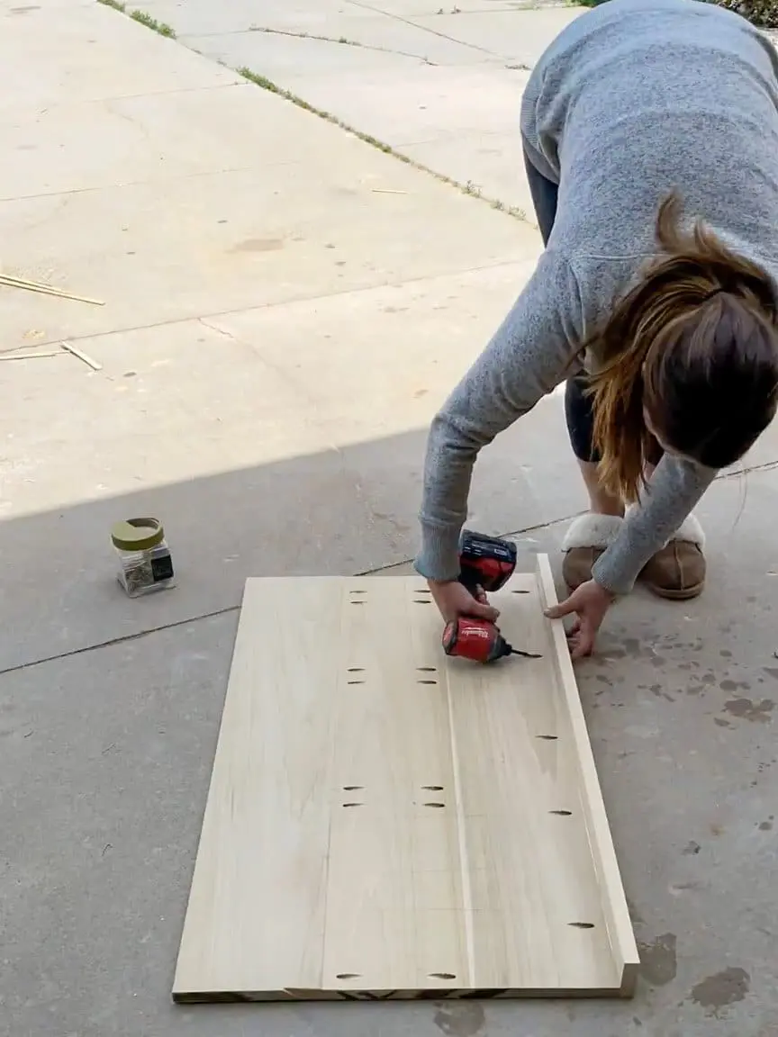 Woman drilling pocket holes into a wooden board for a DIY office desk