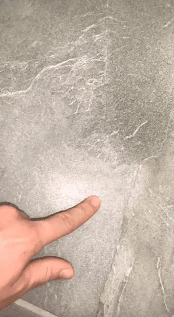 Finger pointing to grey tile