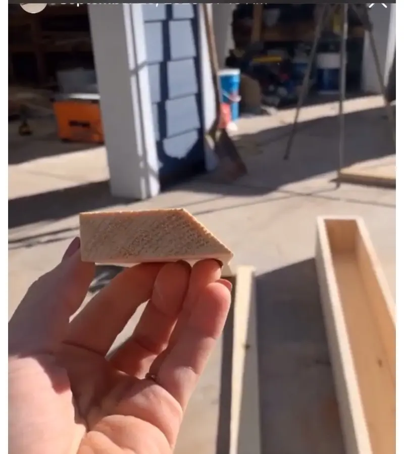 Hand holding French cleat showing 45-degree angled cut for hanging system