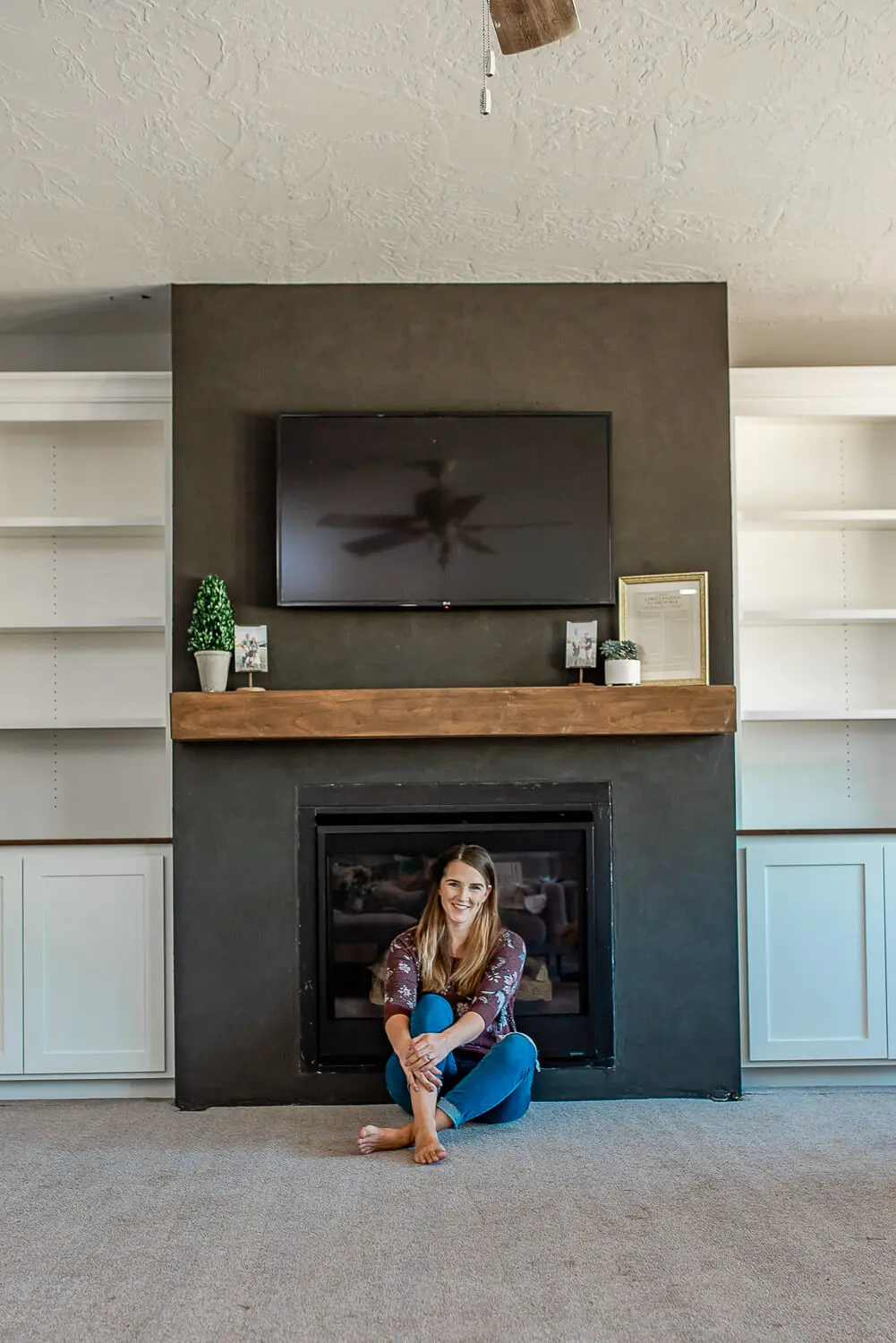 DIY floating fireplace mantel made from pine boards installed above black Roman Clay fireplace