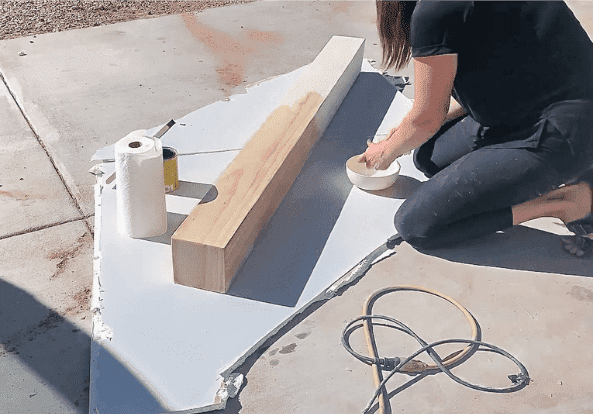 woman applying water to a wooden mantel