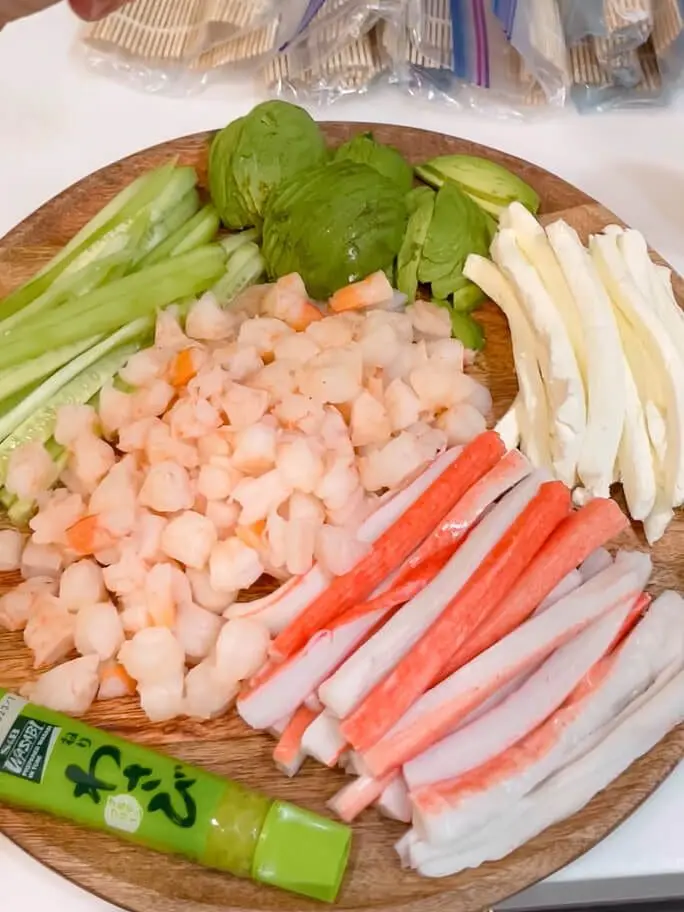 meat and vegetables on a platter for sushi