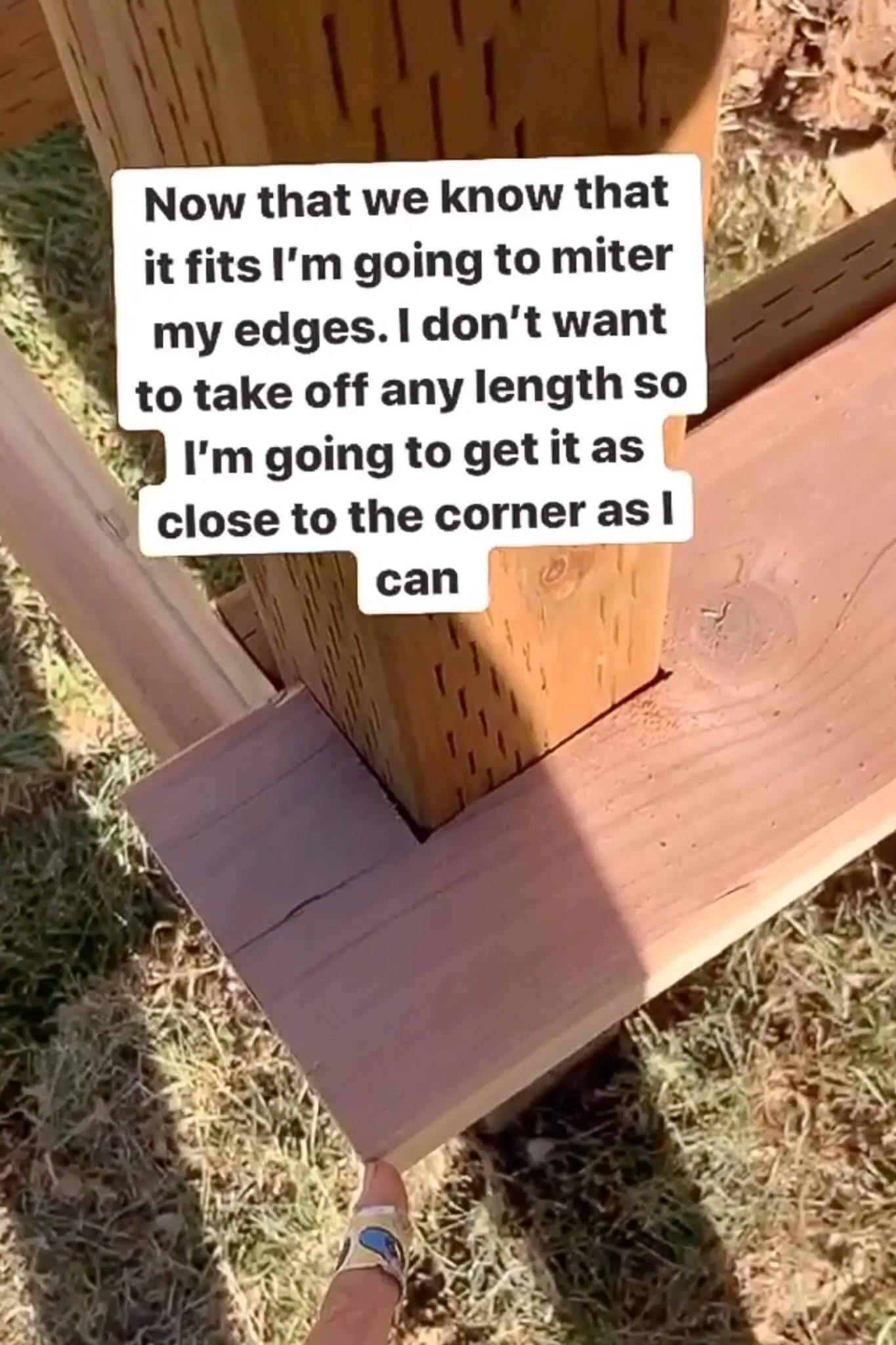 Trim board dry fit tightly around a porch post before mitering the corner during a DIY small front porch build, showing close-up construction detail.