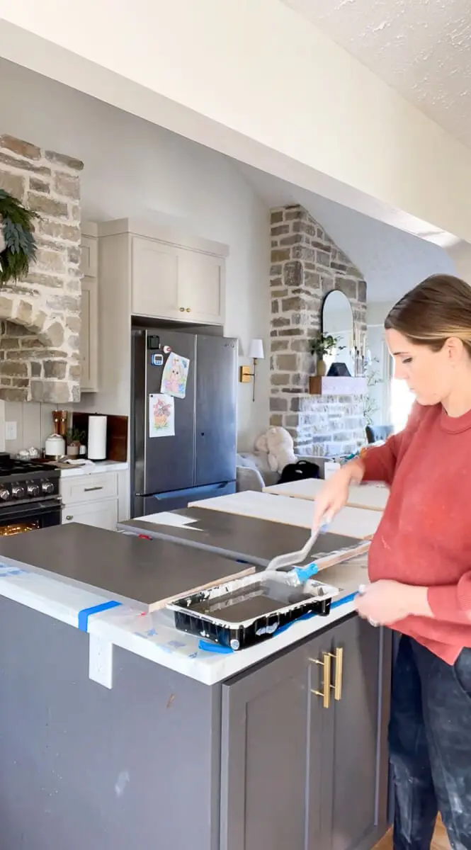 woman painting shelves in her kitchen