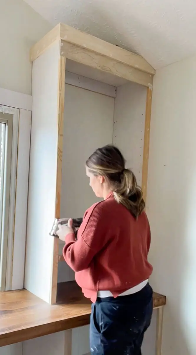 Woman sanding a cabinet