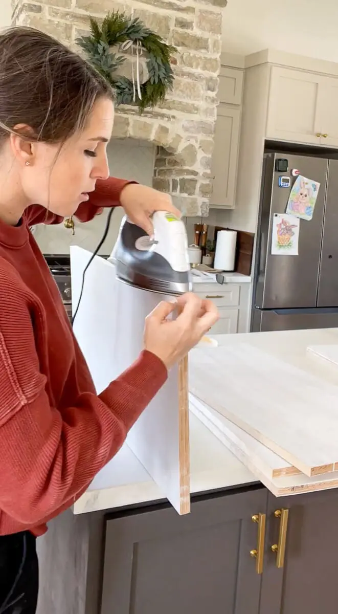 Woman applying edge banding to plywood