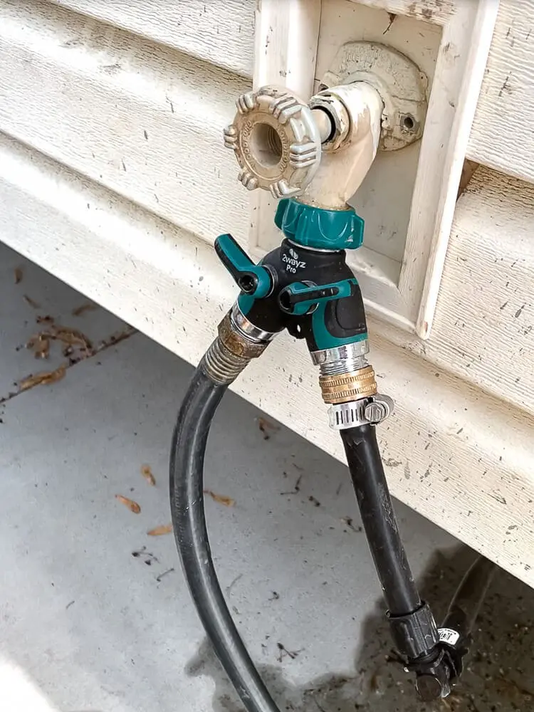 Outdoor hose bib splitter connected to a faucet for running a drip irrigation system and regular garden hose at the same time