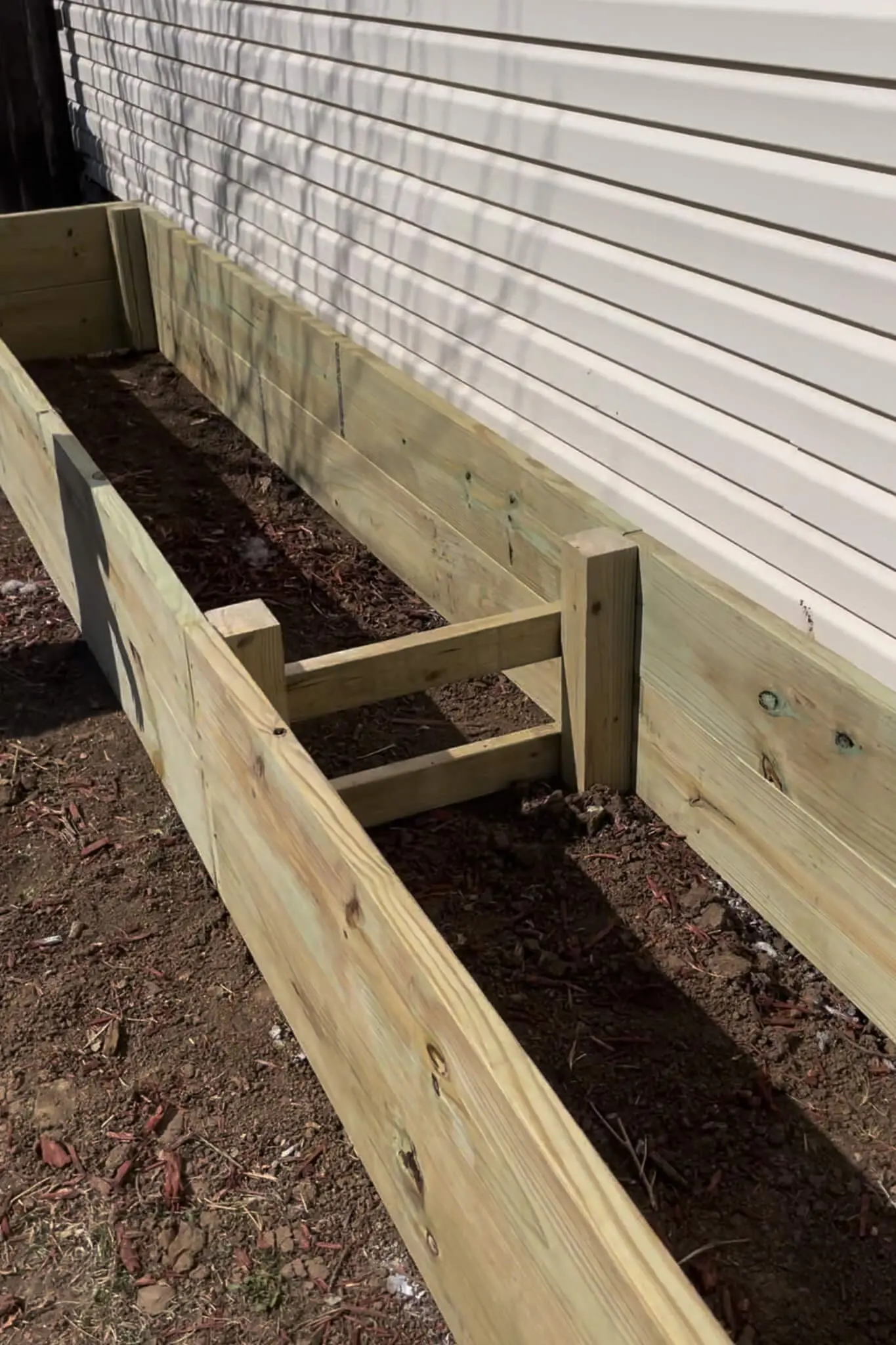 Interior cross brace added to a long raised garden bed to reinforce the walls