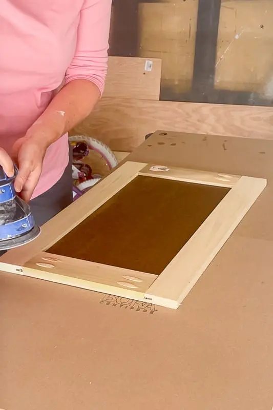 woman sanding a shaker cabinet door