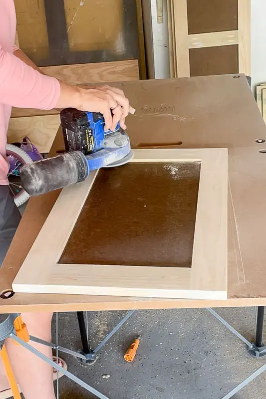 woman sanding a shaker cabinet door