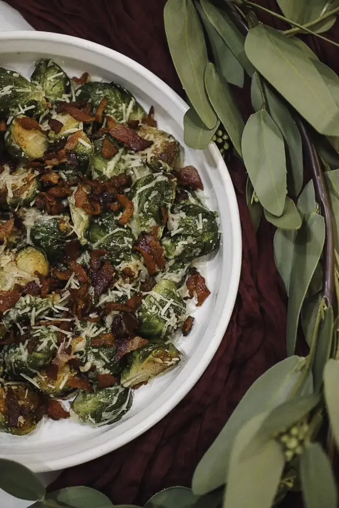 A close-up shot of Brussels sprouts topped with crispy bacon