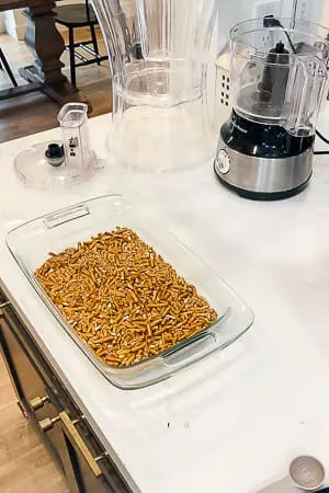 Crushed pretzels spread in a glass baking dish, ready to bake as the base for the raspberry pretzel pie.
