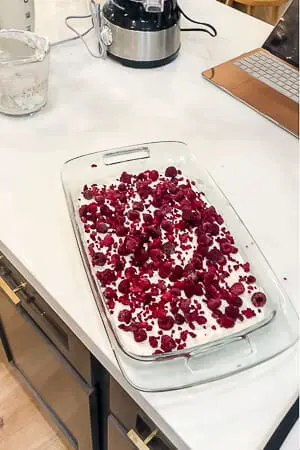 Fresh raspberries scattered over the creamy layer of the raspberry pretzel pie before adding the gelatin topping.