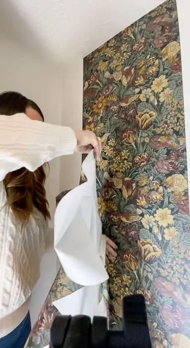 Woman learning how to wallpaper a closet