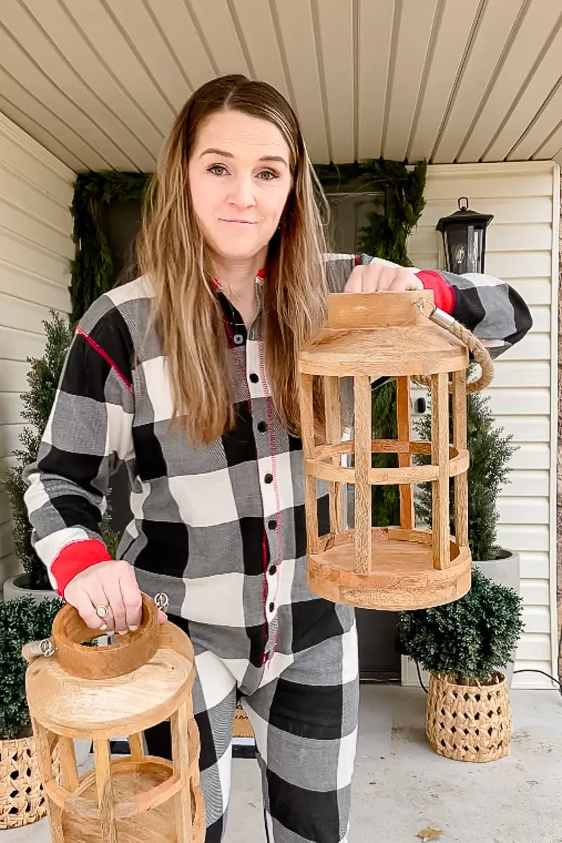 Woman adding wooden lanterns onto front porch