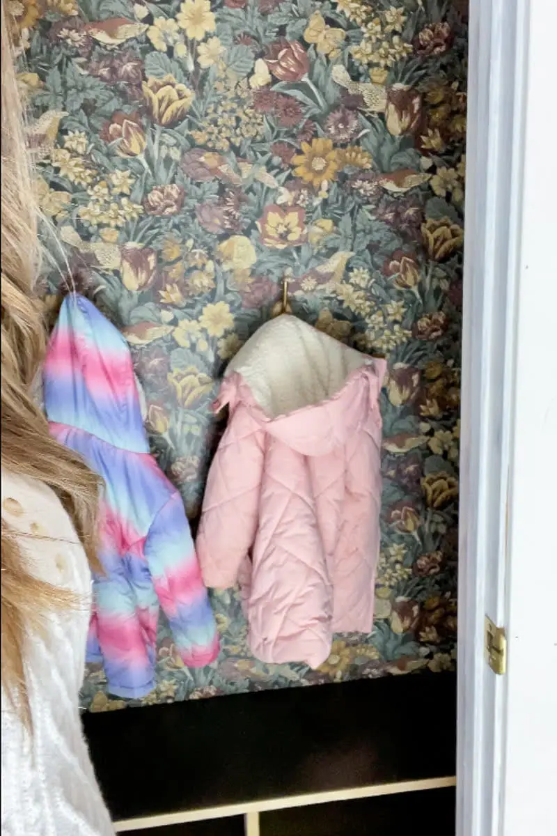 Lower gold hooks holding kids coat in coat closet makeover