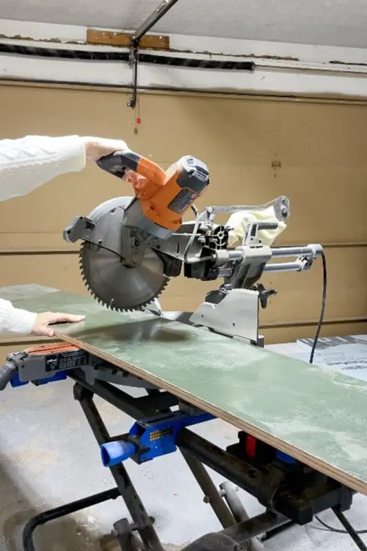 Lady cutting plywood for custom shoe shelf in coat closet