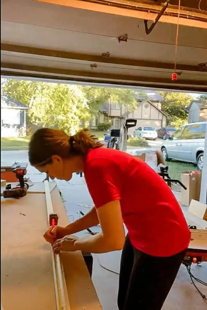 Close-up of a measuring tape marking the correct dimensions for DIY pull-out shelves, ensuring a precise fit inside the kitchen cabinet.