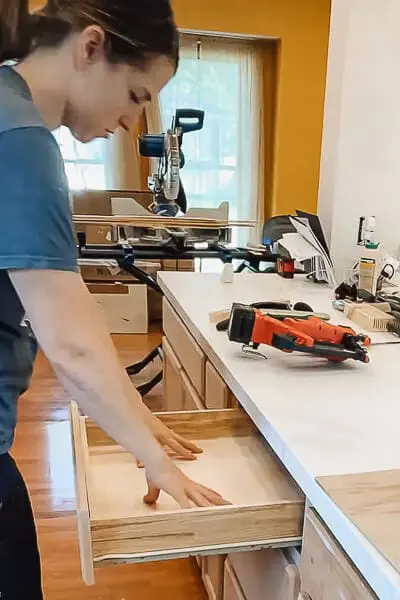 Neatly organized kitchen drawer with dividers holding utensils, cutlery, and kitchen tools.