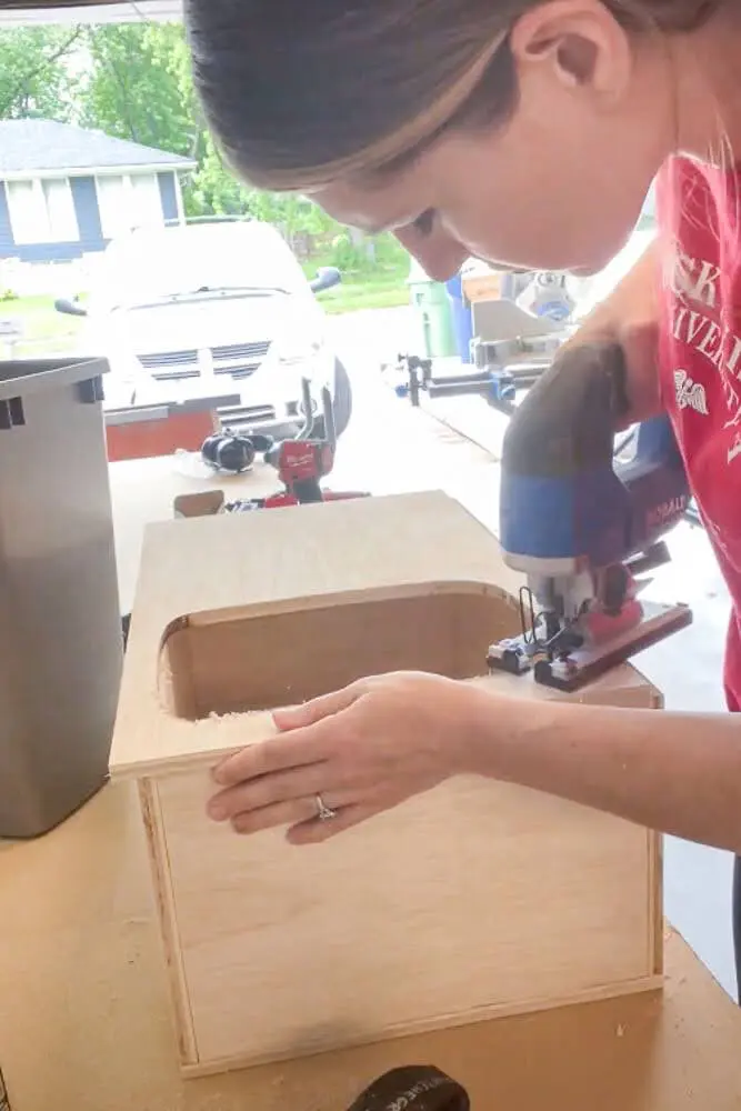 using jigsaw to cut holes into trash bin drawer
