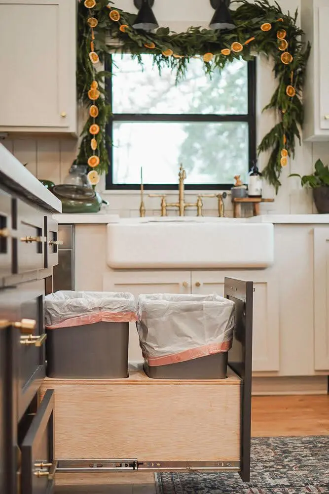 Finished DIY sliding trash drawer in kitchen with kitchen window and sink