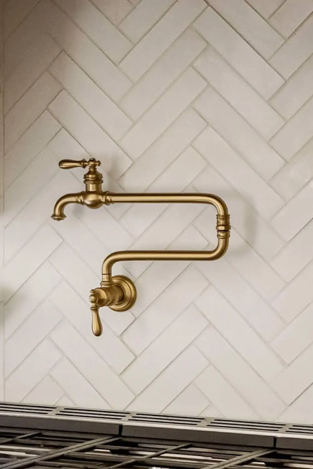 Brass pot filler with herringbone tile backsplash.