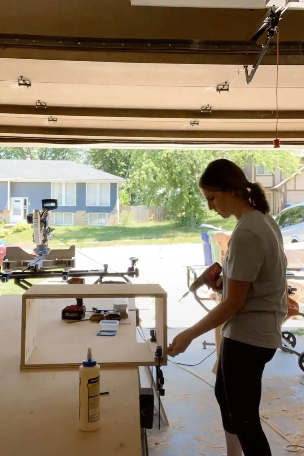 Woman building cabinet box for extending kitchen cabinets to the ceiling.