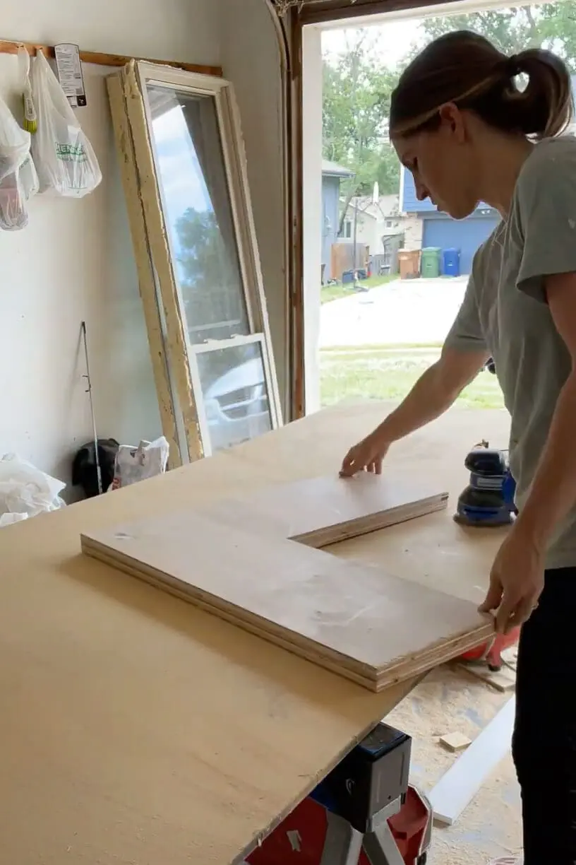 Woman building a corner cabinet box. 