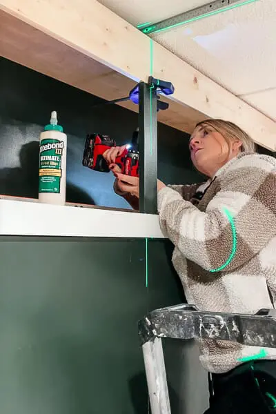 woman using a laser level for a built in