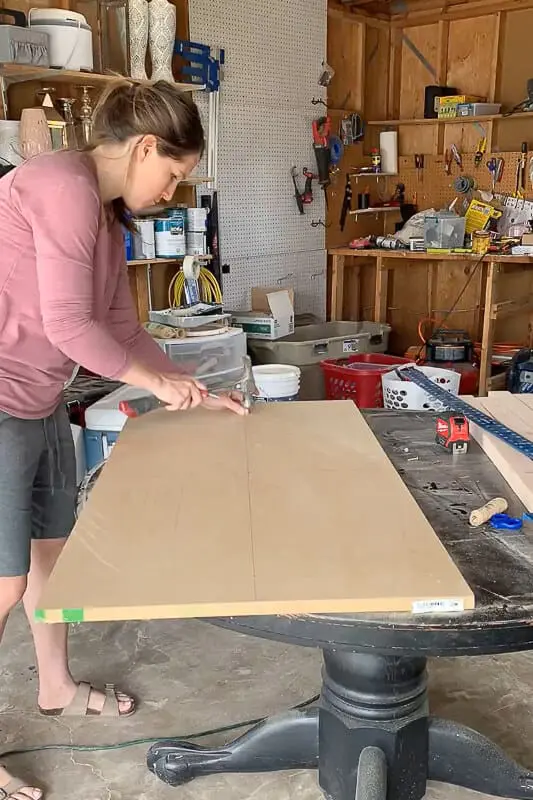 Woman drawing an oval on MDF