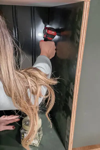 woman assembling cabinet boxes