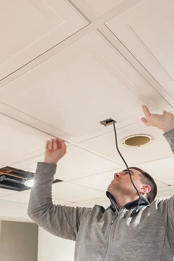 Cutting a drop ceiling tile with a razor