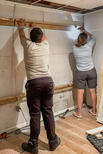 Installing horizontal wood blocks into cinderblock basement wall to support Murphy bed frame
