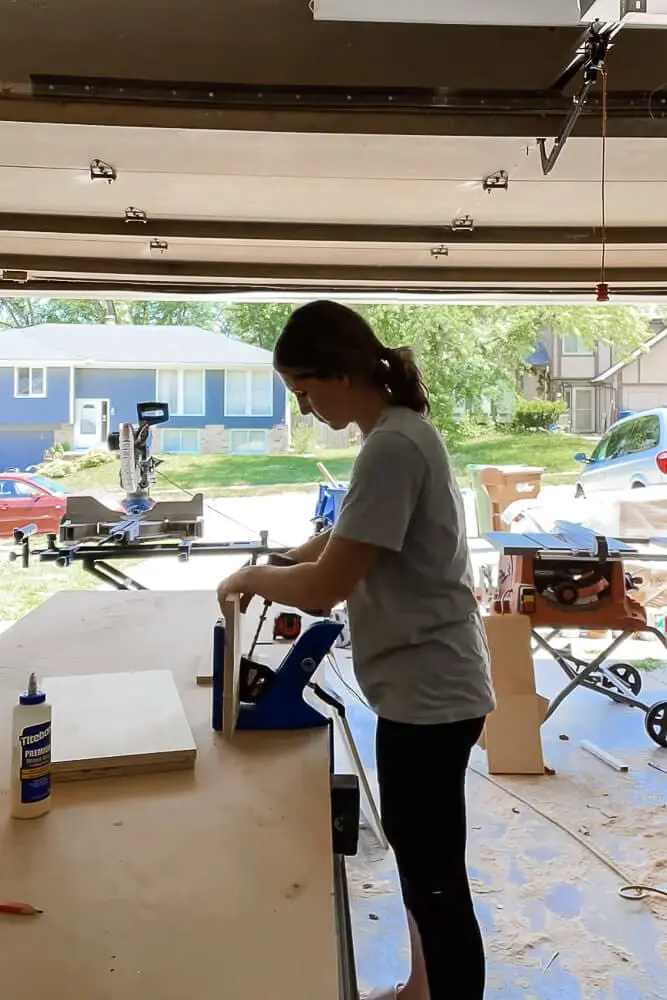 Woman using a Kreg pocket hole jig.