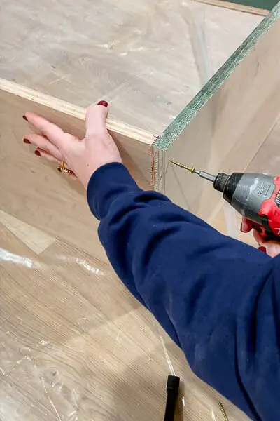 woman assembling cabinet boxes