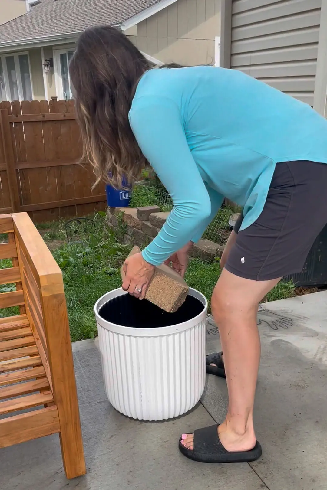 Adding faux greenery to a backyard patio.